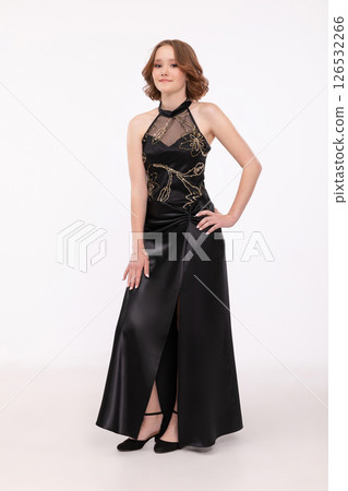 An Elegant Woman Dressed in a Stunning Black Evening Dress Featuring a Chic Slit An Elegant Woman Dressed in a Stunning Black Evening Dress Featuring a Chic Slit 126532266
