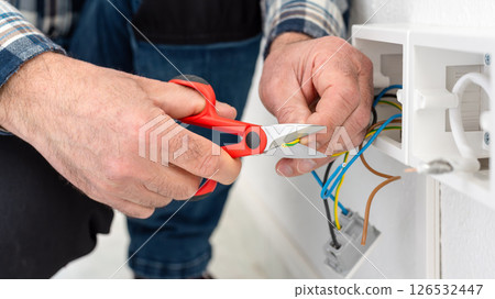 Electrician at work on a residential electrical system. Electricity. 126532447
