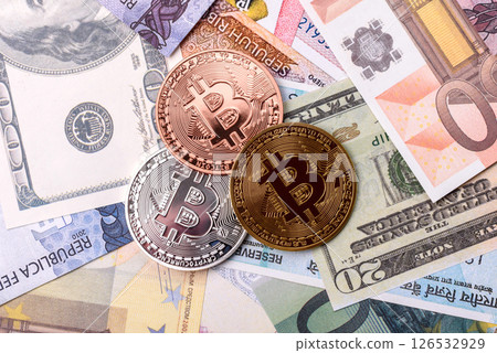 Round metal bitcoin on a background of paper banknotes of different currencies 126532929
