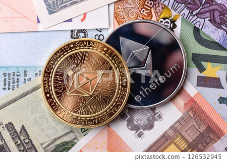 Round metal ethereum on a background of paper banknotes Round metal ethereum on a background of paper banknotes 126532945