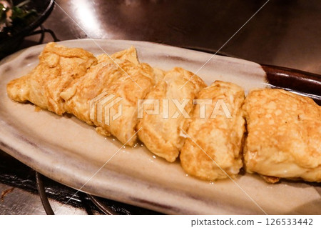 close up of Japanese pan fried egg omelette rolls (Tamagoyaki) cut into pieces on a white plate 126533442