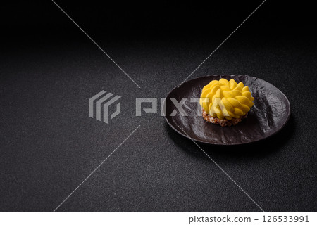 Round sweet tart of yellow color with citrus and passion fruit flavor 126533991