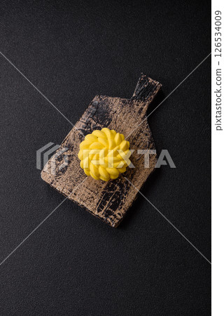 Round sweet tart of yellow color with citrus and passion fruit flavor 126534009