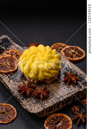 Round sweet tart of yellow color with citrus and passion fruit flavor 126534018