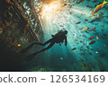 Scuba diver navigates the underwater world, exploring a decaying shipwreck teeming with colorful fish and vibrant coral, showcasing the beauty and mystery of the deep sea 126534169