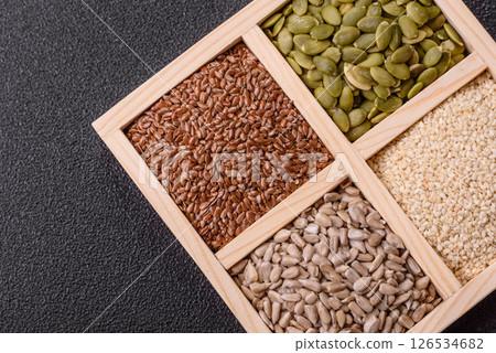 Sunflower, pumpkin, flax and sesame seeds in a wooden box Sunflower, pumpkin, flax and sesame seeds in a wooden box 126534682