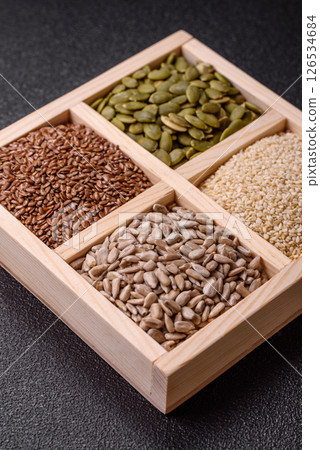 Sunflower, pumpkin, flax and sesame seeds in a wooden box 126534684