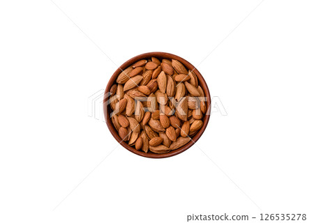 Roasted or raw almond nuts in shell in bowl 126535278