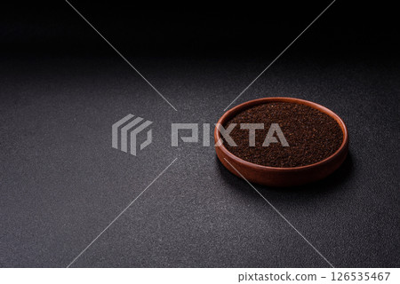 Black tea dry crushed in bowl 126535467