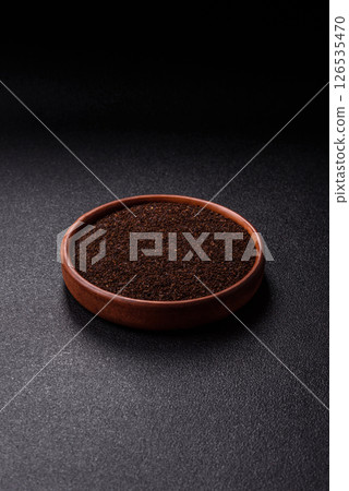 Black tea dry crushed in bowl 126535470
