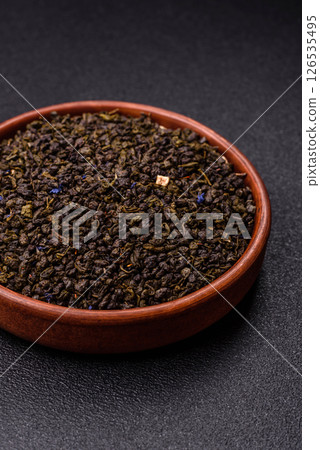 Dry green tea with soursop piece, knapweed petals in bowl 126535495