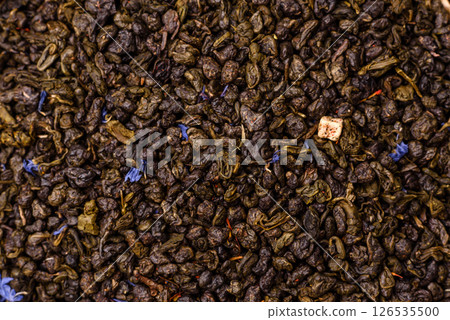 Dry green tea with soursop piece, knapweed petals in bowl 126535500