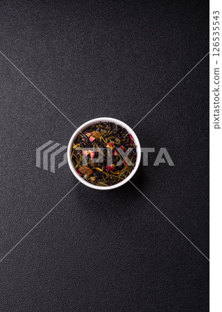 Dry tea mix blend black, green and flower petals in bowl Dry tea mix blend black, green and flower petals in bowl 126535543