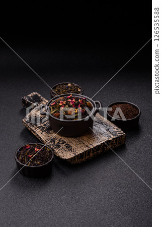 Dry tea mix blend black, green and flower petals in bowl 126535588