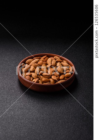 Roasted or raw almond nuts in shell in bowl 126535686