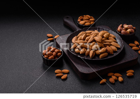 Roasted or raw almond nuts in shell in bowl 126535719