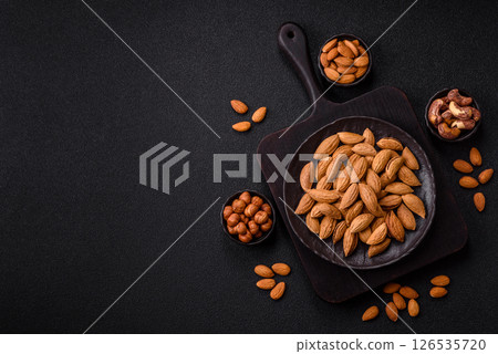 Roasted or raw almond nuts in shell in bowl Roasted or raw almond nuts in shell in bowl 126535720