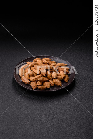 Roasted or raw almond nuts in shell in bowl 126535734