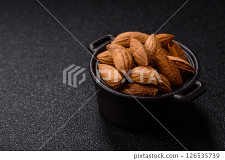 Roasted or raw almond nuts in shell in bowl Roasted or raw almond nuts in shell in bowl 126535739