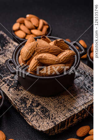 Roasted or raw almond nuts in shell in bowl 126535746