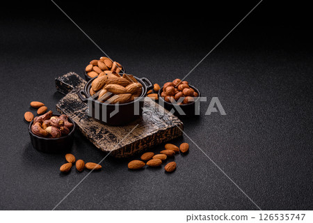 Roasted or raw almond nuts in shell in bowl 126535747