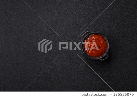 Red sauce or ketchup with salt and spices in ceramic sauce boat 126536070
