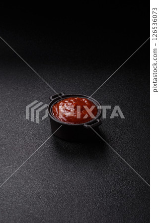Red sauce or ketchup with salt and spices in ceramic sauce boat 126536073