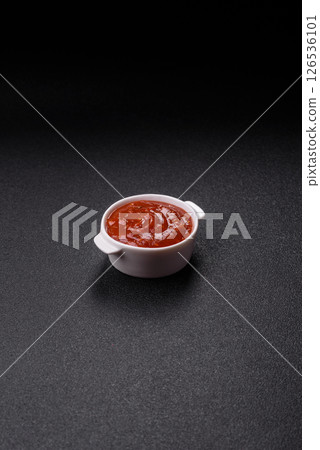 Red sauce or ketchup with salt and spices in ceramic sauce boat 126536101