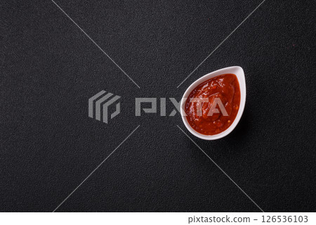 Red sauce or ketchup with salt and spices in ceramic sauce boat 126536103