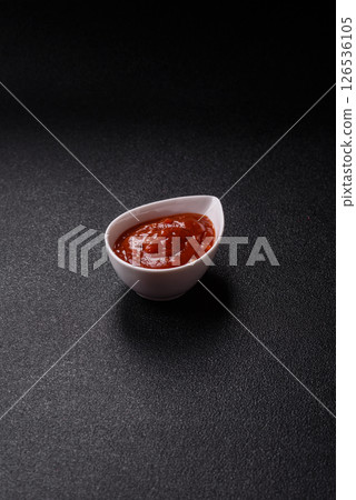 Red sauce or ketchup with salt and spices in ceramic sauce boat 126536105