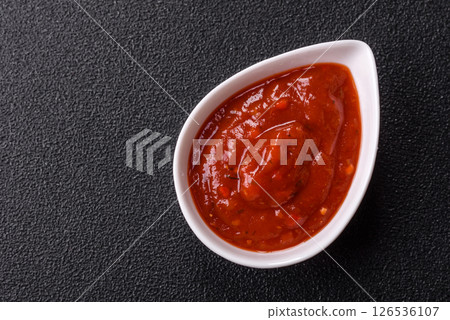 Red sauce or ketchup with salt and spices in ceramic sauce boat 126536107