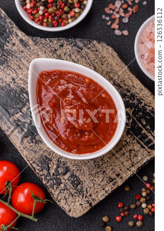 Red sauce or ketchup with salt and spices in ceramic sauce boat 126536112