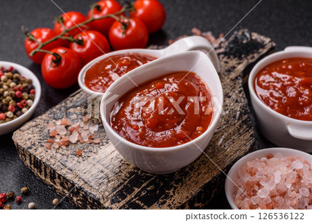 Red sauce or ketchup with salt and spices in ceramic sauce boat 126536122