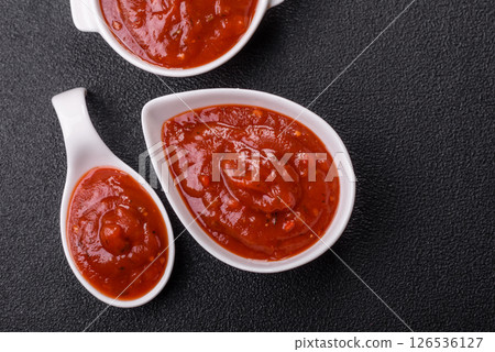 Red sauce or ketchup with salt and spices in ceramic sauce boat 126536127