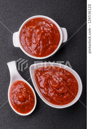 Red sauce or ketchup with salt and spices in ceramic sauce boat 126536128
