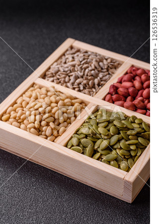 A box of peanuts and cedar nuts and sunflower and pumpkin seeds 126536319