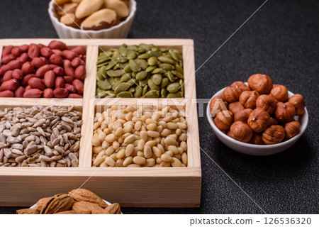 A box of peanuts and cedar nuts and sunflower and pumpkin seeds 126536320