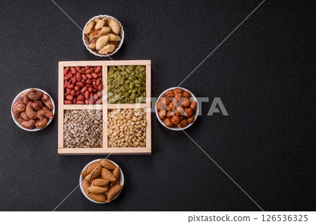 A box of peanuts and cedar nuts and sunflower and pumpkin seeds 126536325