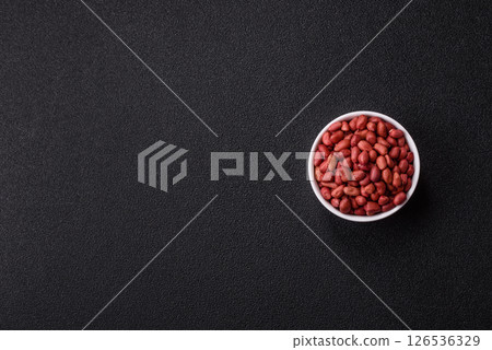 Peanuts or peeled graundnut in a bowl on a dark concrete background Peanuts or peeled graundnut in a bowl on a dark concrete background 126536329