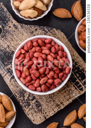 Peanuts or peeled graundnut in a bowl on a dark concrete background Peanuts or peeled graundnut in a bowl on a dark concrete background 126536338