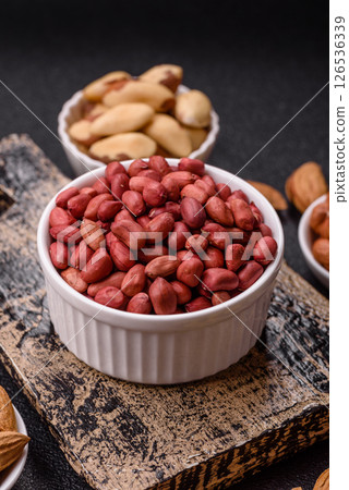 Peanuts or peeled graundnut in a bowl on a dark concrete background Peanuts or peeled graundnut in a bowl on a dark concrete background 126536339
