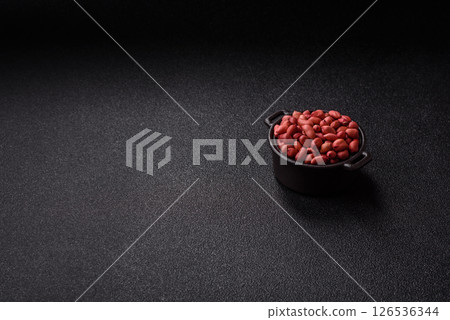 Peanuts or peeled graundnut in a bowl on a dark concrete background Peanuts or peeled graundnut in a bowl on a dark concrete background 126536344