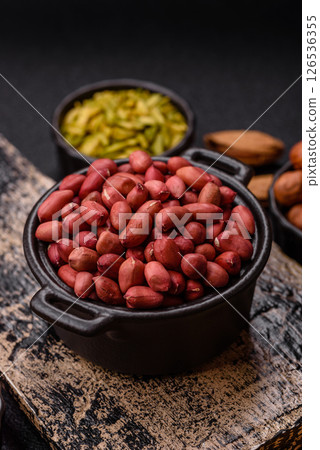 Peanuts or peeled graundnut in a bowl on a dark concrete background Peanuts or peeled graundnut in a bowl on a dark concrete background 126536355