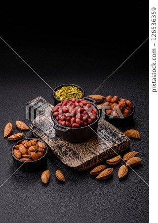 Peanuts or peeled graundnut in a bowl on a dark concrete background Peanuts or peeled graundnut in a bowl on a dark concrete background 126536359