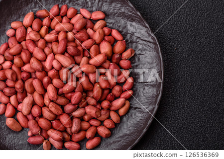 Peanuts or peeled graundnut in a bowl on a dark concrete background Peanuts or peeled graundnut in a bowl on a dark concrete background 126536369