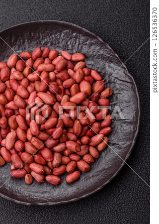 Peanuts or peeled graundnut in a bowl on a dark concrete background Peanuts or peeled graundnut in a bowl on a dark concrete background 126536370