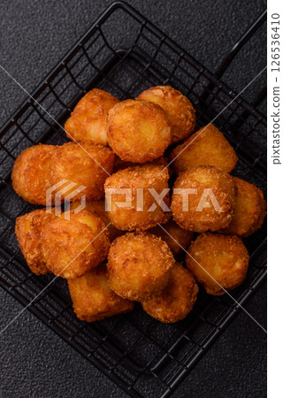 Cheese or potato croquettes, balls fried in breading with salt, spices Cheese or potato croquettes, balls fried in breading with salt, spices 126536410