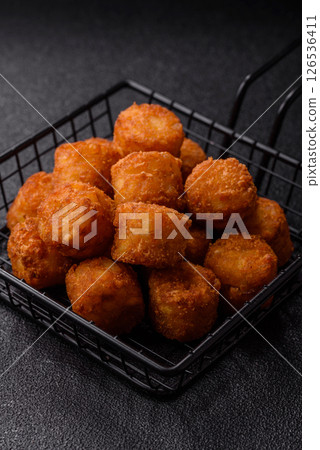Cheese or potato croquettes, balls fried in breading with salt, spices 126536411