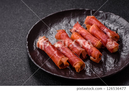 Cheese and meat, jamon or prosciutto rolled into a roll 126536477