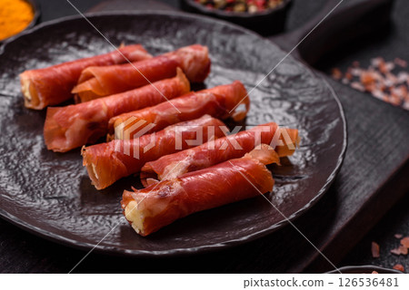 Cheese and meat, jamon or prosciutto rolled into a roll 126536481